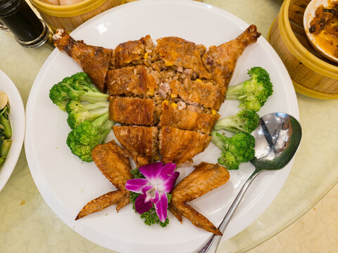 Fried chicken stuffed with rice and vegetables on white plate