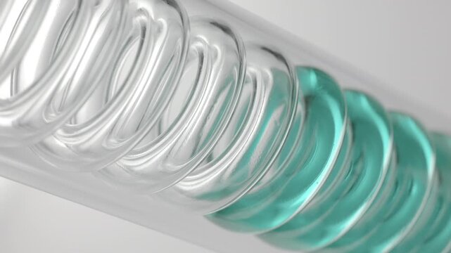 Pale cyan transparent fluid flowing through the spiral of an inclined coil laboratory condenser, filling it up on grey background | Methylene blue solution cosmetic element concept