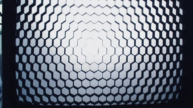 Lighting equipment with the honeycomb pattern casting unique patterned light. Camera zooming out