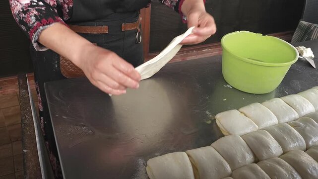 Moroccan Woman Preparing Traditional Msemen Flatbread Dough by Hand. Close-up video of a woman's hands stretching and oiling dough while preparing traditional Moroccan msemen (msemmen) flatbread. 
