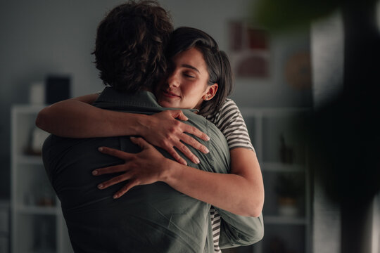 Young woman embracing man in intimate moment, showing love and emotional support in a relationship