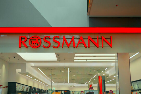 Rossmann drugstore retail chain store entrance with bold red illuminated signage inside a bright modern shopping mall