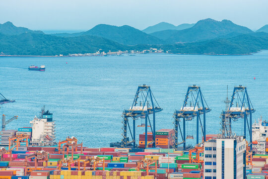 Shenzhen, China - May 22, 2026: Cargo terminal with container cranes overlooking coastal waters and mountains at Shenzhen Port. Maritime infrastructure, international logistics, seaborne trade