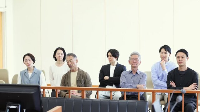 法廷の傍聴席で裁判を見守るさまざまな世代の人々
