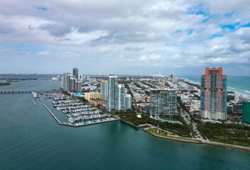 Fototapeta premium Yacht docked at Miami marina. Aerial view of coastline in Miami. Miami skyline above harbor. Famous Miami Beach marine from above. Marina with yachts.