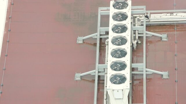 Long white HVAC unit with six circular fans mounted on grey steel frame. Top down architectural perspective. Symmetrical industrial engineering layout with geometric precision. high quality 4k video.