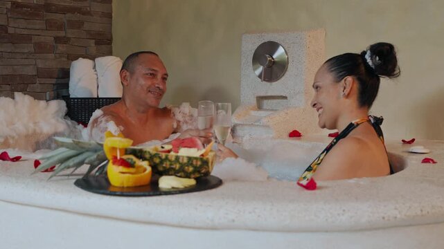 Romantic couple drinking champagne in a hot tub