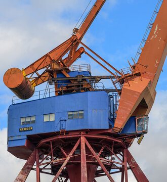 Gothenburg, Sweden - May 30 2026: Weathered harbor crane towering against blue sky in industrial waterfront scene.
