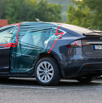 Gothenburg, Sweden - september 04 2024: Damaged Tesla electric vehicle with plastic taped window parked outdoors.