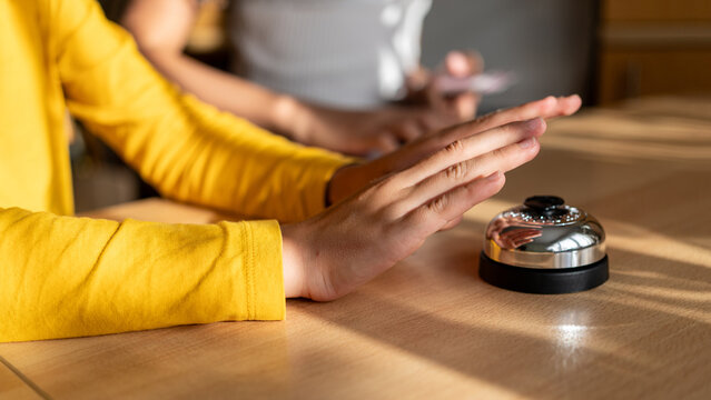 Child Hand Ready to Press Quiz Buzzer. Close-up of a child&rsquo;s hand hovering above a metal quiz buzzer during a competitive educational game at home.