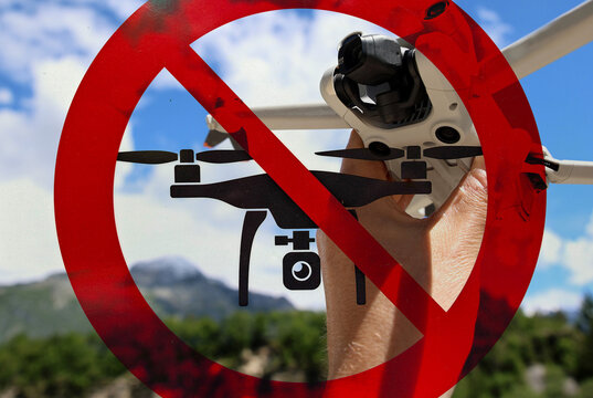 Drone in Front of a No Drone Flying Sign Symbolizing Restricted Airspace and Flight Regulations
