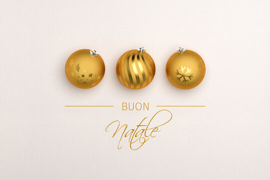 Three golden christmas baubles on paper background. Italian Message "Buon Natale" (Merry Christmas) below.