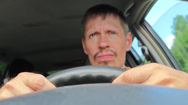 Driver shows signs of tiredness while driving on a sunny day