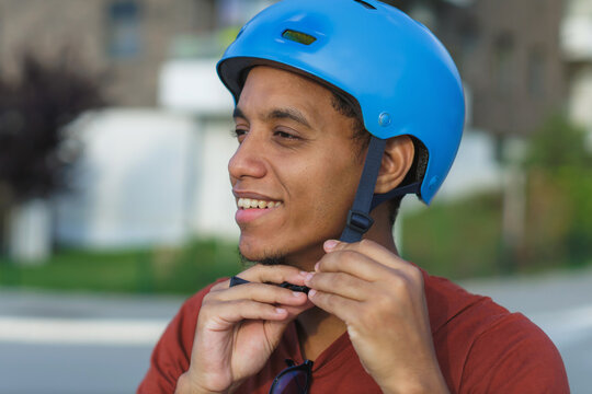 Young man puts on a cycling helmet