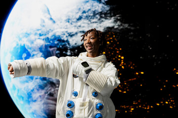 Ecstatic astronaut dancing, celebrating finishing mission and approaching Earth with space shuttle  African American woman delighted by outer space experience, concept of human wonder. © DC Studio