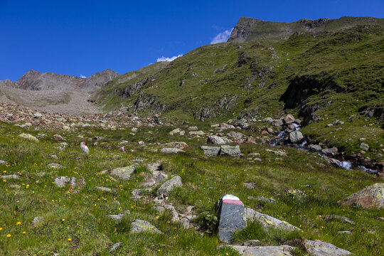 Idyllisches Alpental mit Bergbach und gr&uuml;nen Bergh&auml;ngen