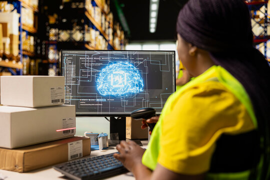 African American woman scans shipping labels with AI neural network support, using package tracking software to process online shopping orders and manage warehouse fulfillment operations.