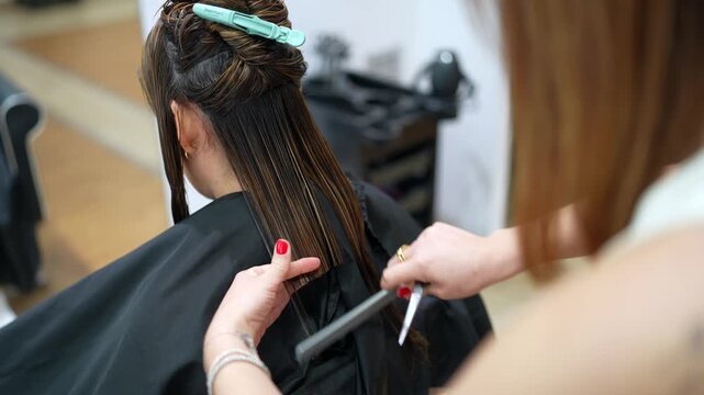 Hairdresser cutting long hair with scissors