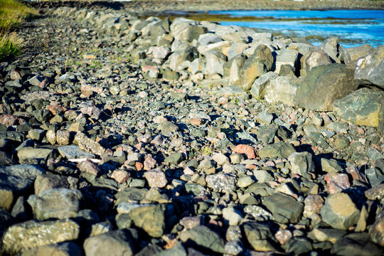 Rocky breakwater and riprap along calm ocean coastline providing shore protection