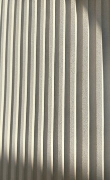 Close up detail of textured fluted wall or profiled wall, suitable for architectural facade backgrounds or home design content. 
