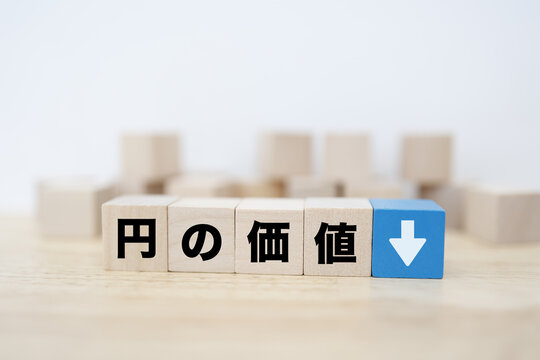 円の価値下落。円安。下矢印ブロック。経済イメージ。コピースペースあり