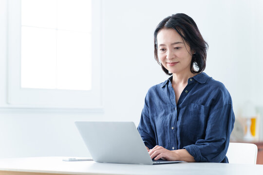 自宅でデスクワークをする中高年女性