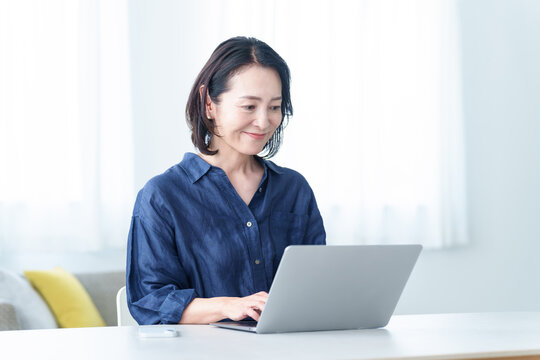 自宅でデスクワークをする中高年女性
