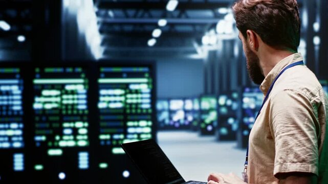 System administrator monitors energy efficient supercomputers in a data center, linking renewable power, lower consumption and sustainable computing operations around data center supercomputers.