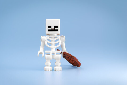 Minecraft Skeleton toy figure stands beside a brown Bow resting on the floor against a light blue background on Jul 25, 2026 in Jakarta, Indonesia
