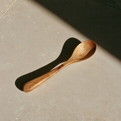 Fototapeta premium Hand-carved olive wood spoon with worn bowl on stone surface