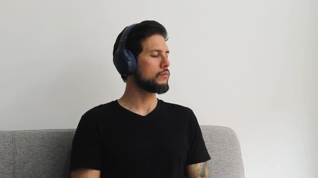 Detailed view of a latin man using a headset with the eyes closed into a reflexive attitude