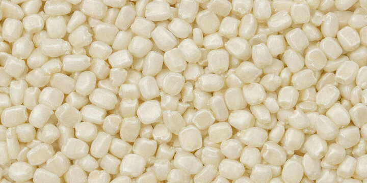 White pearl sprinkles background. Macro texture of small edible sugar beads for baking.