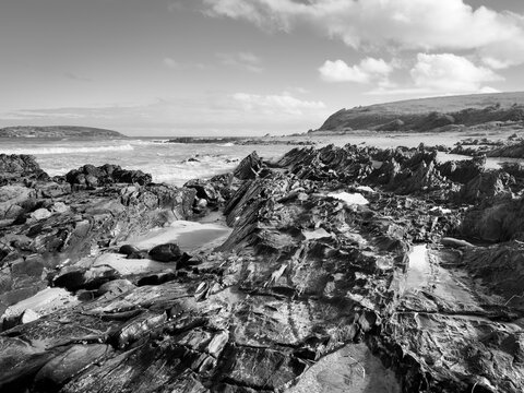 Landscape views of rocks and ocean from beaches along the Victor Harbor Heritage Trail on the Fleurieu Peninsula in South Australia in black and white