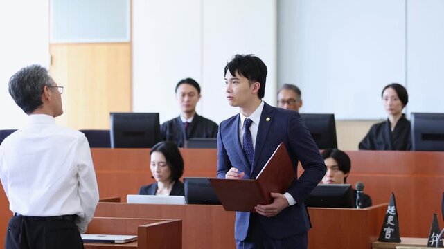 法廷で証人尋問を行う若手弁護士と証人の法廷シーン