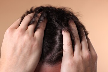 Fototapeta premium Man examining his head on beige background, closeup