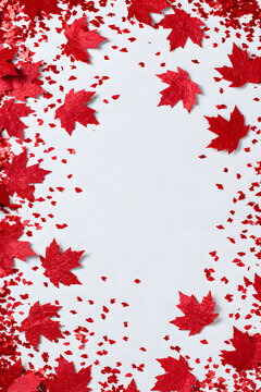 Canada's Independence Day festivities feature red cut maple leaves and confetti displayed against a white vertical backdrop