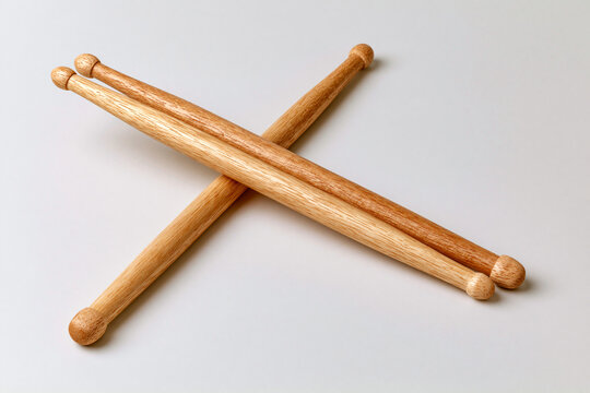 Pair of wooden drumsticks crossed on grey surface music and rhythm