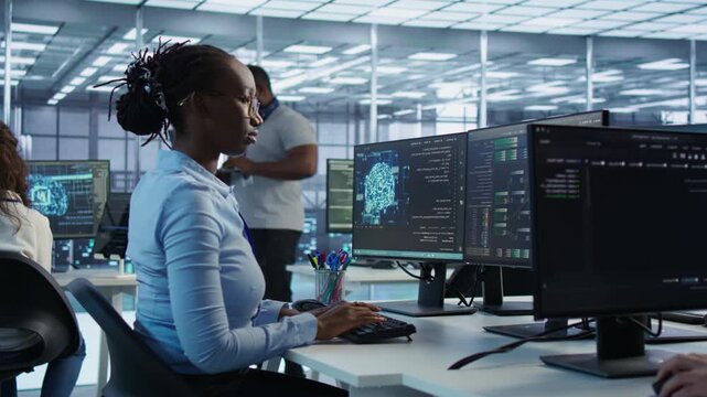 Supervisor overseeing worker using AI system software from a secondary camera angle while showing secure storage, threat prevention and cybersecurity monitoring.
