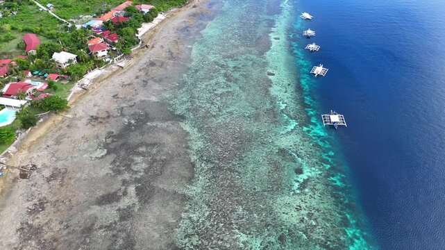 Outrigger boats moored along a coral reef drop-off, Moalboal, Cebu, Philippines