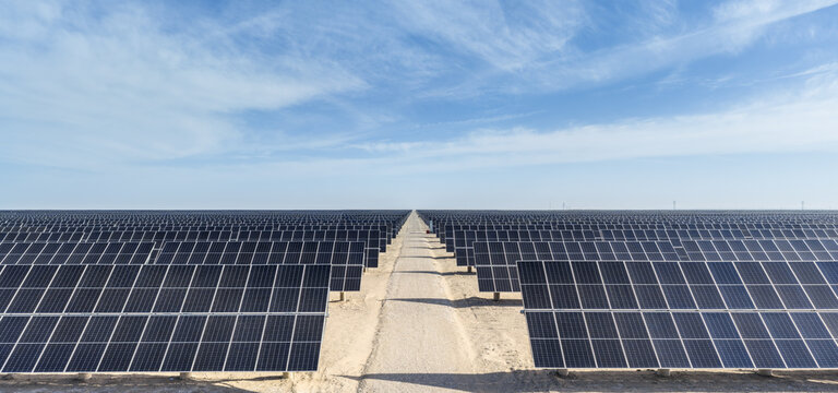Symmetrical Solar Panel Rows Along Desert Road