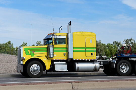 Peterbilt semi truck towing a flatbed trailer along a roadway, illustrating freight transportation, commercial trucking, logistics, and cargo delivery