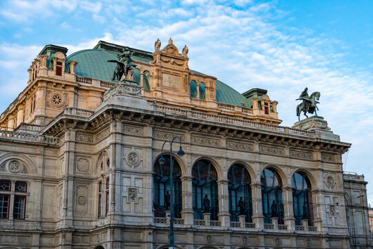 Historic Building with Green Roof and Sculptures Under Blue Sky