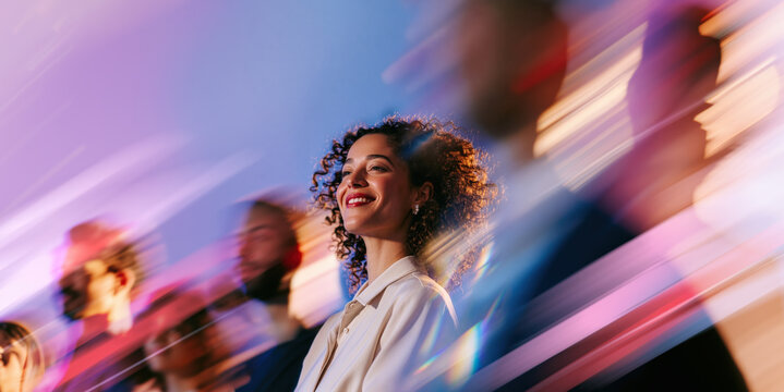 Optimistic Young African Professional Woman Looking Ahead Through Blue Pink Pastel Crowd Motion