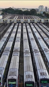 Vertical aerial view of multiple metro trains parked in parallel rows at a railway depot