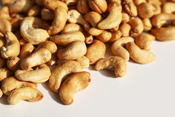 Fototapeta premium Roasted cashew nuts on a white background.