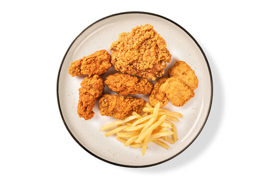 Top view of  delicious fast food with golden crispy fried chicken, potato French fries, and chicken nuggets on a white plate. Isolated on a white background. Top view