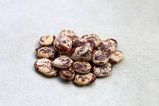 Raw lima beans on grey background.