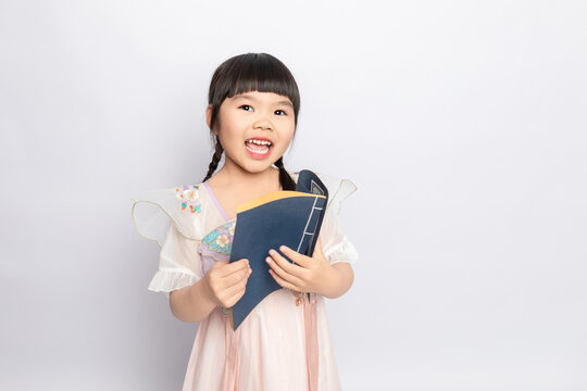 A young girl wearing Hanfu reading a book against a white background