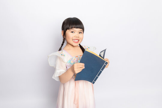 A young girl wearing Hanfu reading a book against a white background