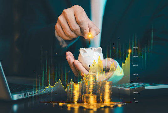 Businessman putting coin into piggy bank with rising stock graph overlay and stacks of gold coins, investment growth and wealth planning concept.